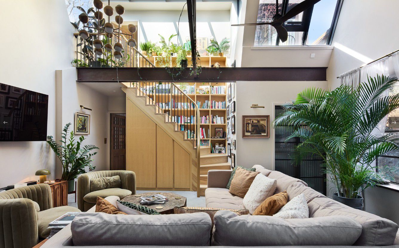 Light-filled design-led living room with mezzanine, joinery staircase and library wall completed by a vetted contractor